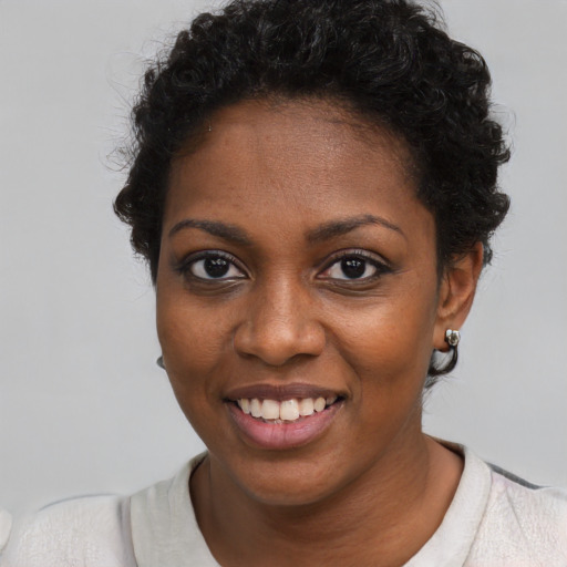 Joyful black young-adult female with short  black hair and brown eyes