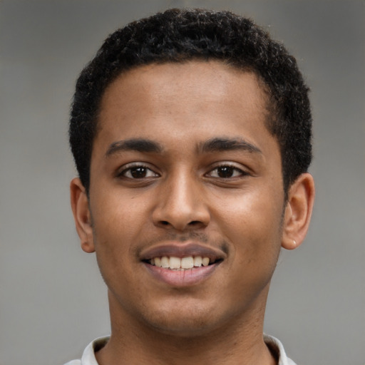 Joyful black young-adult male with short  brown hair and brown eyes