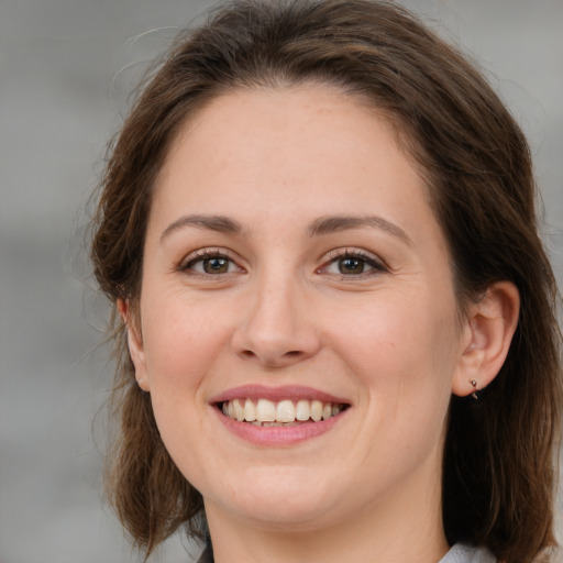 Joyful white young-adult female with medium  brown hair and grey eyes