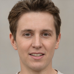 Joyful white adult male with short  brown hair and grey eyes