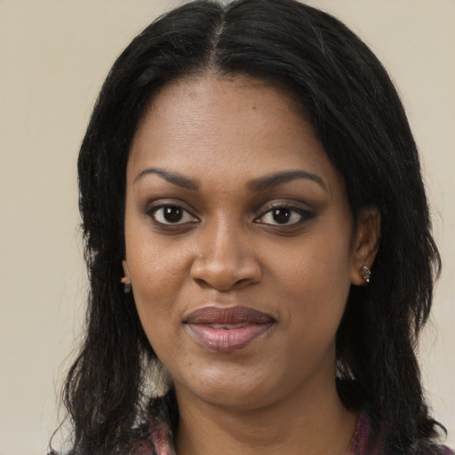 Joyful black young-adult female with long  black hair and brown eyes