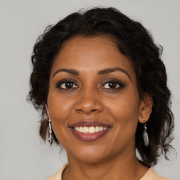 Joyful black adult female with medium  brown hair and brown eyes