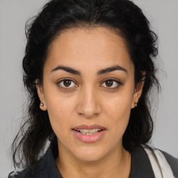 Joyful latino young-adult female with medium  brown hair and brown eyes