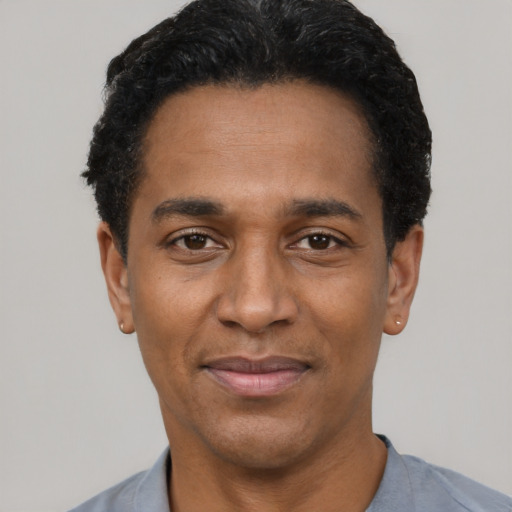 Joyful black adult male with short  black hair and brown eyes
