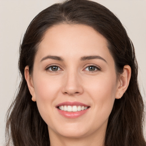 Joyful white young-adult female with long  brown hair and brown eyes