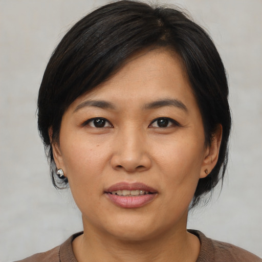 Joyful asian young-adult female with medium  black hair and brown eyes