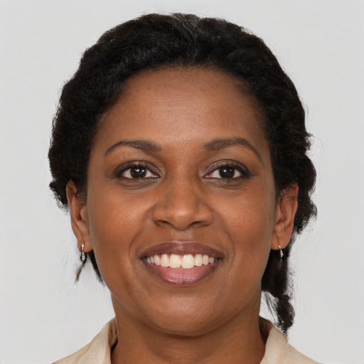 Joyful black adult female with medium  brown hair and brown eyes