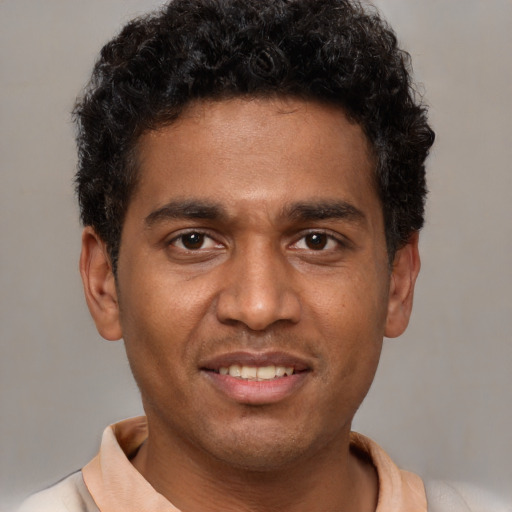 Joyful black young-adult male with short  brown hair and brown eyes