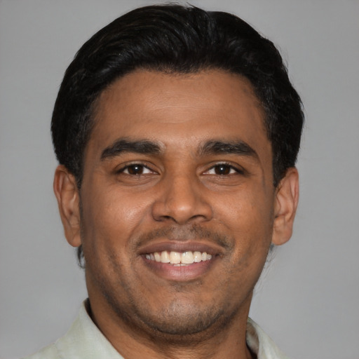 Joyful latino young-adult male with short  brown hair and brown eyes