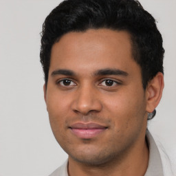 Joyful latino young-adult male with short  black hair and brown eyes