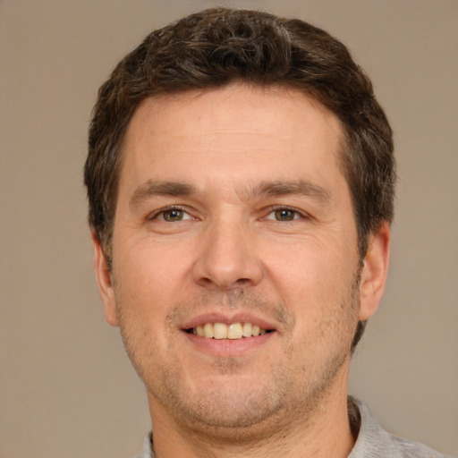 Joyful white adult male with short  brown hair and brown eyes