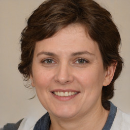 Joyful white adult female with medium  brown hair and blue eyes