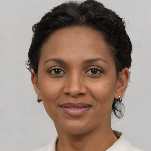 Joyful black adult female with short  brown hair and brown eyes