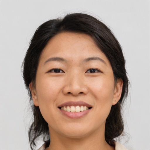 Joyful asian young-adult female with medium  brown hair and brown eyes