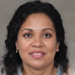 Joyful black adult female with long  brown hair and brown eyes