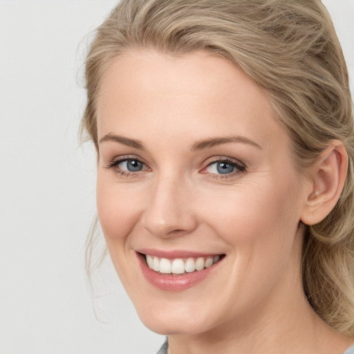 Joyful white young-adult female with medium  brown hair and blue eyes