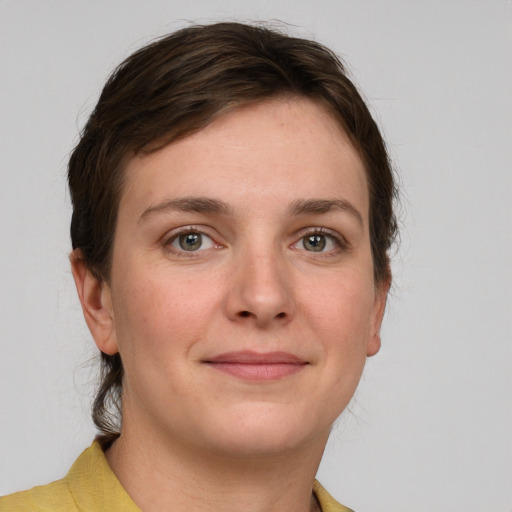 Joyful white young-adult female with medium  brown hair and grey eyes