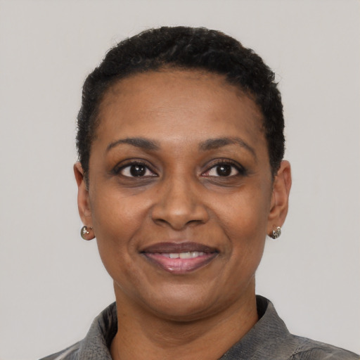 Joyful black adult female with short  black hair and brown eyes