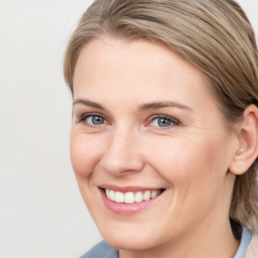 Joyful white young-adult female with medium  brown hair and blue eyes