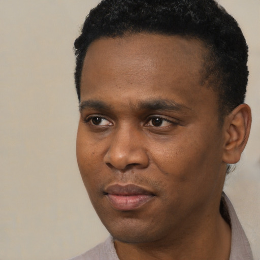 Joyful black young-adult male with short  black hair and brown eyes