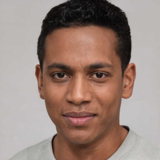 Joyful black young-adult male with short  black hair and brown eyes