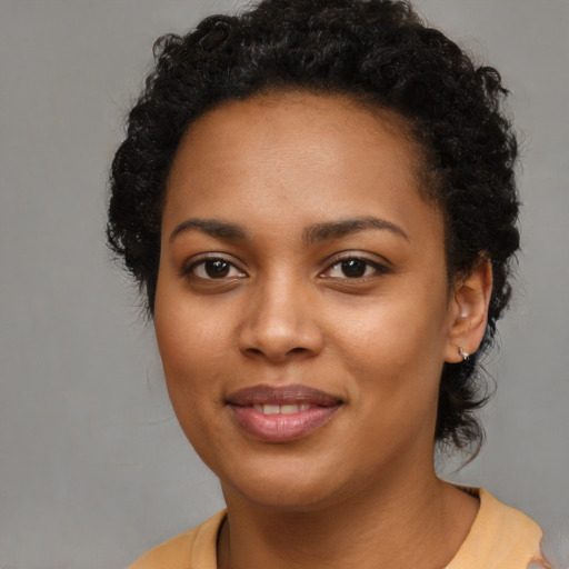 Joyful black young-adult female with medium  brown hair and brown eyes