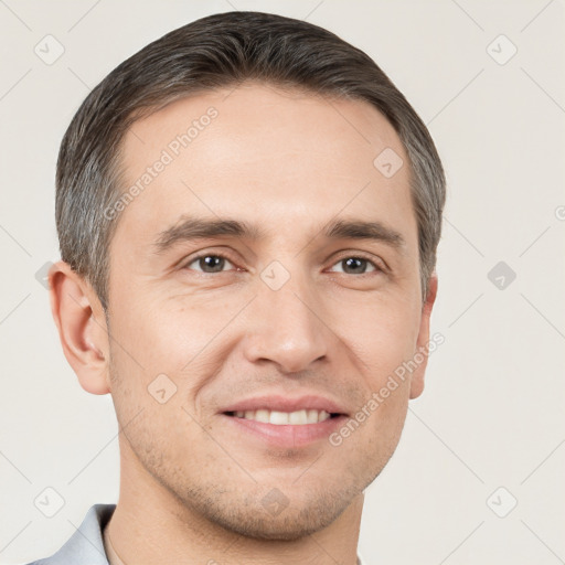 Joyful white young-adult male with short  brown hair and grey eyes