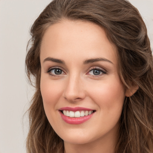 Joyful white young-adult female with long  brown hair and green eyes