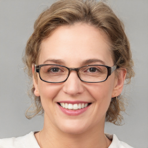 Joyful white adult female with medium  brown hair and blue eyes