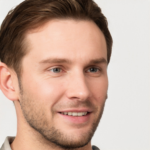 Joyful white young-adult male with short  brown hair and grey eyes