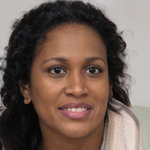 Joyful black young-adult female with long  brown hair and brown eyes