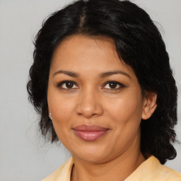 Joyful latino adult female with medium  brown hair and brown eyes