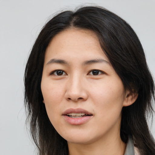 Joyful asian young-adult female with long  brown hair and brown eyes