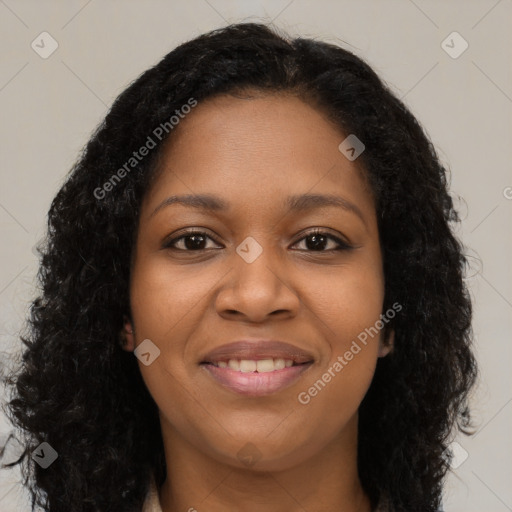 Joyful black young-adult female with long  brown hair and brown eyes