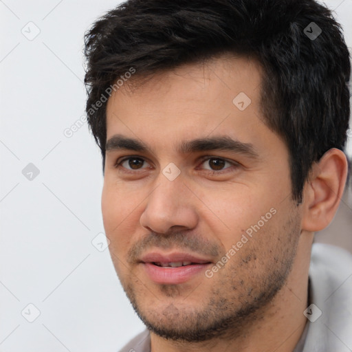 Joyful white young-adult male with short  black hair and brown eyes