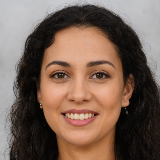 Joyful latino young-adult female with long  brown hair and brown eyes
