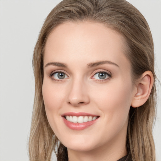 Joyful white young-adult female with long  brown hair and blue eyes