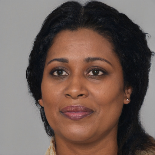 Joyful black adult female with long  black hair and brown eyes