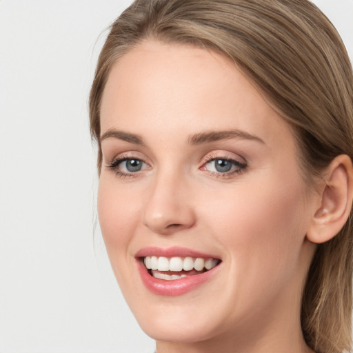 Joyful white young-adult female with long  brown hair and grey eyes