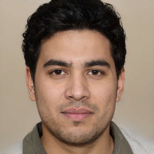 Joyful white young-adult male with short  black hair and brown eyes