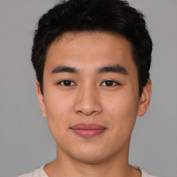 Joyful asian young-adult male with short  black hair and brown eyes