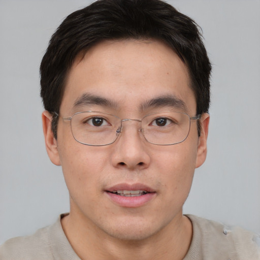 Joyful asian adult male with short  brown hair and brown eyes