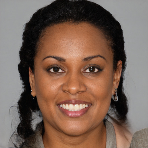 Joyful black young-adult female with medium  brown hair and brown eyes