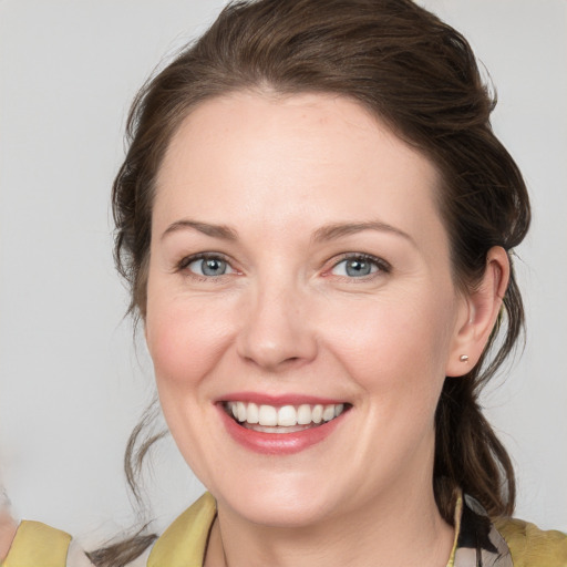 Joyful white young-adult female with medium  brown hair and grey eyes