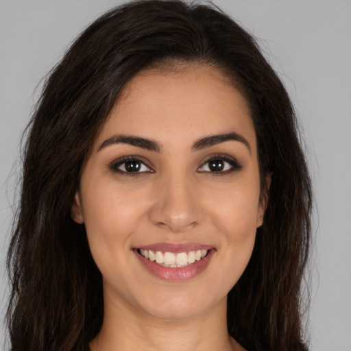 Joyful white young-adult female with long  brown hair and brown eyes