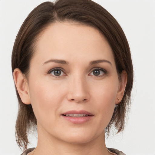 Joyful white young-adult female with medium  brown hair and grey eyes