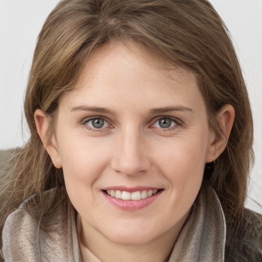 Joyful white young-adult female with long  brown hair and grey eyes