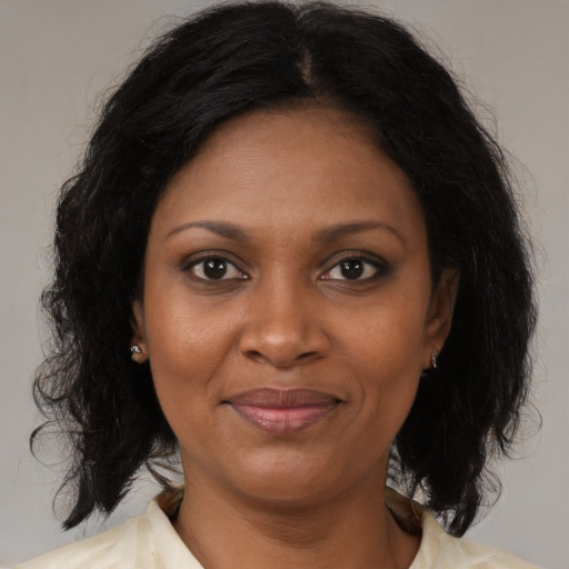 Joyful black adult female with medium  brown hair and brown eyes