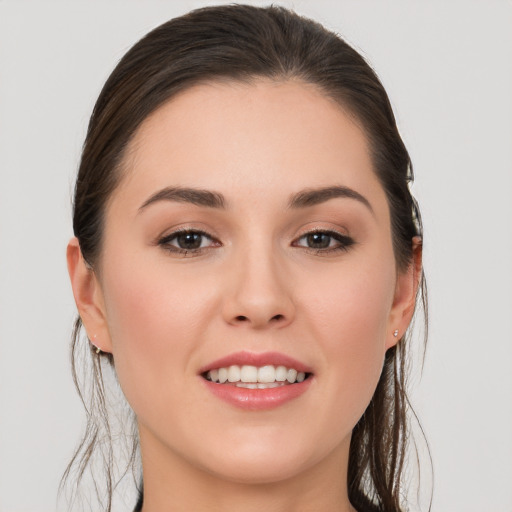 Joyful white young-adult female with long  brown hair and brown eyes