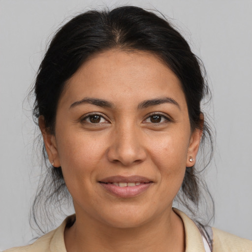 Joyful latino young-adult female with medium  brown hair and brown eyes